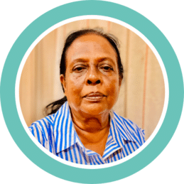 A circle photo with a teal border showing Foothold community member Sarojini, who faced an unexpected personal crisis.